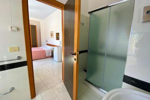 a bathroom with a shower and a toilet and a bedroom at Majestic Suite in San Benedetto del Tronto