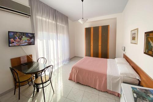 a bedroom with a bed and a desk and a table at Majestic Suite in San Benedetto del Tronto