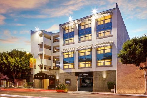 a large building on a city street with trees at Carlyle Inn in Los Angeles