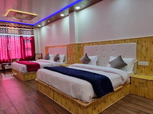 two beds in a hotel room with red lights at Grand Kailash Khajjiar in Dalhousie