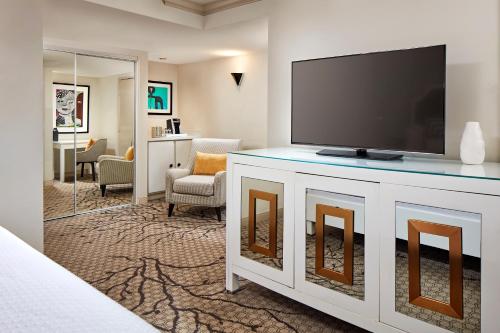 a living room with a flat screen tv on a cabinet at Carlyle Inn in Los Angeles