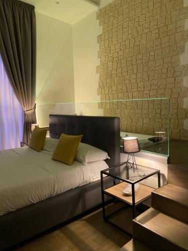 Un dormitorio con una cama y una mesa de cristal. en Salotto Toledo, en Nápoles