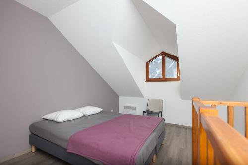 - une chambre avec un lit doté d'une couverture violette et d'une fenêtre dans l'établissement Les Chalets du Jardin Alpin, à La Salle Les Alpes