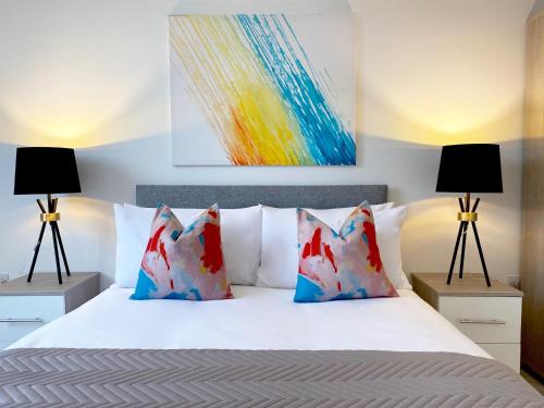 a bedroom with a white bed with two lamps at Altitude at Fleet Heights Apartment One in Fleet