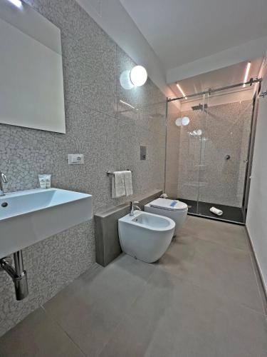 a bathroom with a toilet and a sink and a shower at Resort La Battigia Beach & Spa in Alcamo Marina