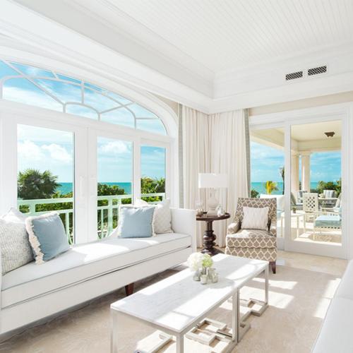 a living room with a white couch and a large window at The Shore Club Turks & Caicos in Grace Bay