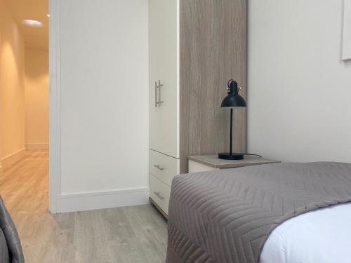a bedroom with a bed and a lamp on a dresser at Peak at Fleet Heights Apartment Four in Fleet