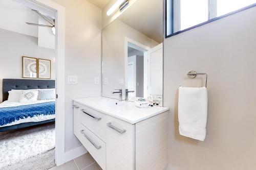 ein weißes Badezimmer mit Waschbecken und Spiegel in der Unterkunft Yampa Cottage in Steamboat Springs