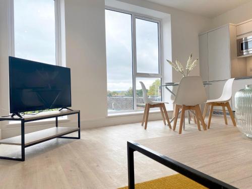 a living room with a television and a table with chairs at Skyline at Fleet Heights Apartment Six in Fleet
