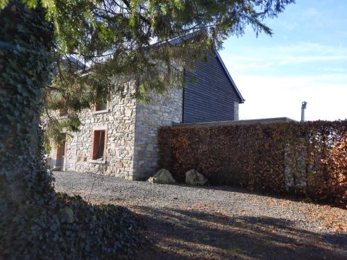 a stone building with a hedge in front of it at Les 12 bois du cerf in Tailles
