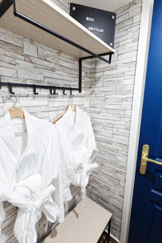 a group of white shirts hanging on a wall at Romance spa tropical Le Havre in Le Havre