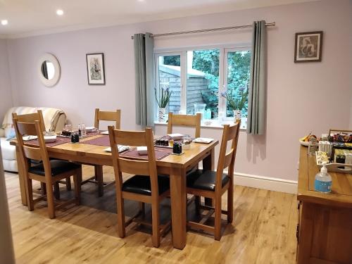 a dining room with a wooden table and chairs at Summat Else B & B in New Quay