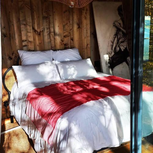 1 dormitorio con 1 cama con manta roja y blanca en Le monde d'Echozellia en Saint-Germain-des-Champs