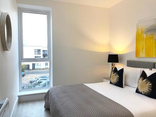 a bedroom with a bed and a large window at Apex at Fleet Heights Apartment Five in Fleet