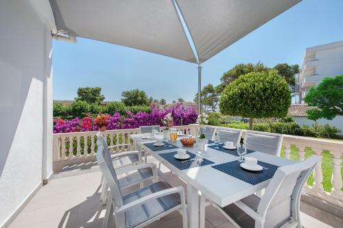 una mesa blanca y sillas en un balcón con flores en Can Pere Bou, en Alcudia