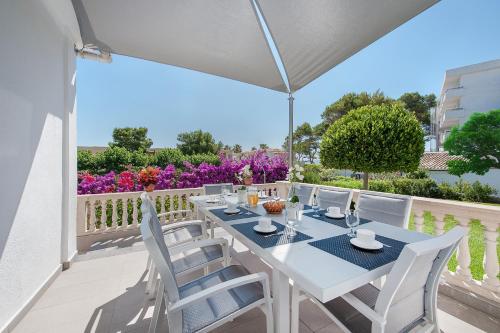 a white table and chairs on a balcony with flowers at Can Pere Bou in Alcudia