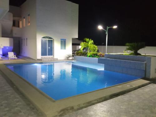 uma piscina no meio de um edifício à noite em Departamento Tonsupa, Conjunto Santorini Blue em Tonsupa