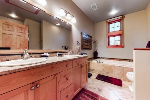 un bagno con due lavandini e un grande specchio di Urban Mountain Getaway & Alpenglow Chalet a Steamboat Springs