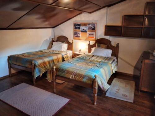 sypialnia z 2 łóżkami w pokoju w obiekcie Casa da Avó Maria, Largo de Santo António, n 97395AL w mieście Freixo de Espada à Cinta