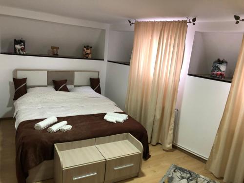 a bedroom with a bed with two towels on it at Serban Home Arenele Romane Marius Nasta in Bucharest
