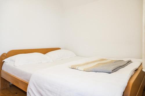 a white bed with white sheets and pillows at Guest House SARA in Žabljak