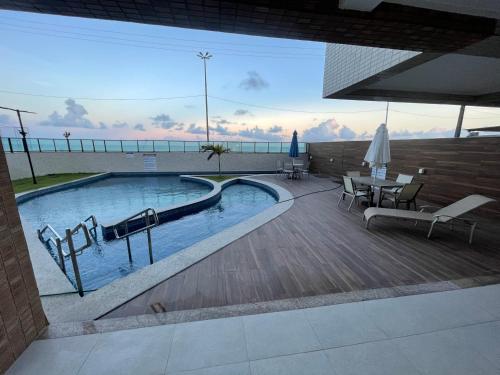a swimming pool with a view of the ocean at Flat Beira Mar - Piedade in Recife