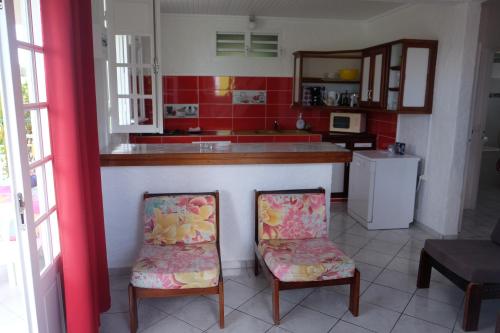 a kitchen with two chairs in front of a counter at LE VILLAGE DE CANADA in Faup