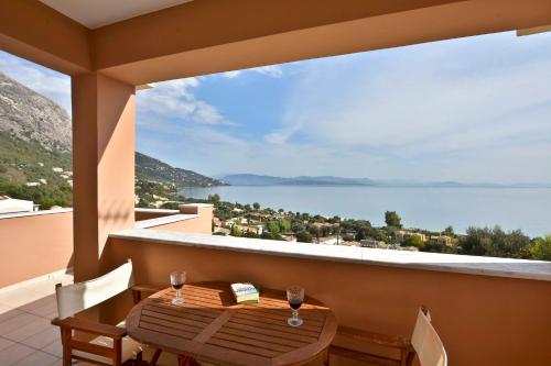 a table on a balcony with a view of the water at Villa Renata Gold in Barbati
