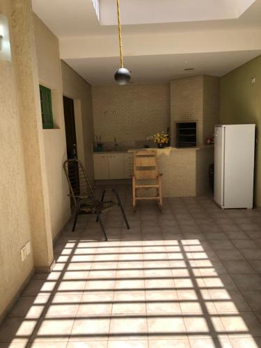 a kitchen with two chairs and a refrigerator at POUSADA Dona Ziza in Maringá
