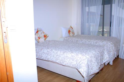 een slaapkamer met een bed met een wit dekbed bij Appartement de Vacances à Mohammedia Paradise in Mohammedia