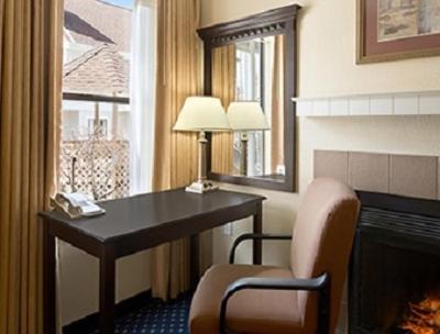 a hotel room with a desk and a fireplace at Hawthorn Extended Stay by Wyndham Fort Wayne in Fort Wayne