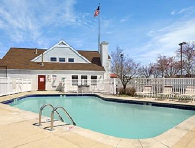 a large swimming pool in front of a house at Hawthorn Extended Stay by Wyndham Fort Wayne in Fort Wayne