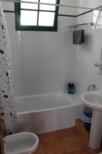 łazienka z białą wanną i umywalką w obiekcie Casa La Esperanza w mieście Playa Blanca