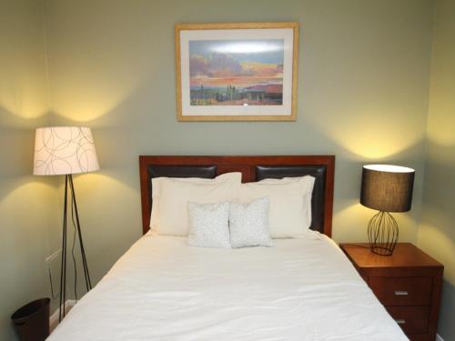 a bedroom with a bed with white sheets and two lamps at Luxury Two Bedroom by Rittenhouse Square in Philadelphia