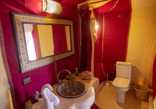 a bathroom with a sink and a toilet and a mirror at Sahara Relax Camps in Zagora