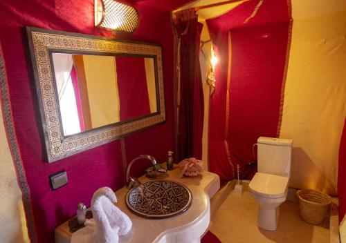 ein Badezimmer mit einem Waschbecken, einem WC und einem Spiegel in der Unterkunft Sahara Relax Camps in Zagora