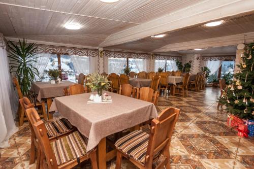 un ristorante con tavoli e sedie e un albero di Natale di Guest house М a Vorokhta
