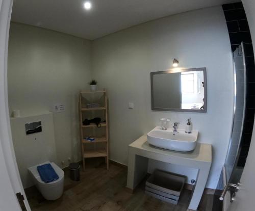 a bathroom with a sink and a toilet at Pé na Areia, Alojamento Local in Porto Covo