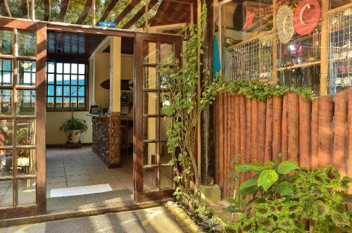 a room with an open door with plants on the wall at Pousada Sanhaço in Abraão