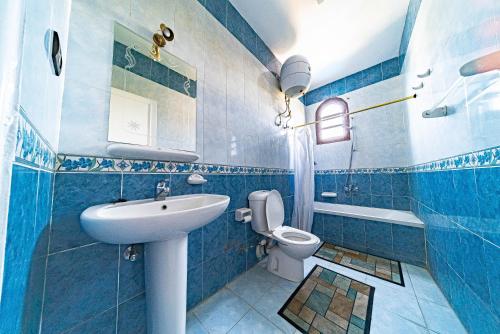 a blue tiled bathroom with a sink and a toilet at Villa Bahri Luxor Apartment in Luxor