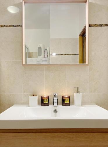 d'un lavabo avec deux bougies. dans l'établissement T2 LE BIEN ETRE MARSEILLE 9ème-wifi-netflix-Métro-Parking-Plage, à Marseille