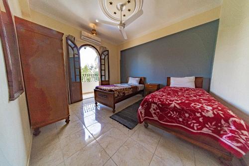 a bedroom with a bed and a couch and a clock at Villa Bahri Luxor Apartment in Luxor