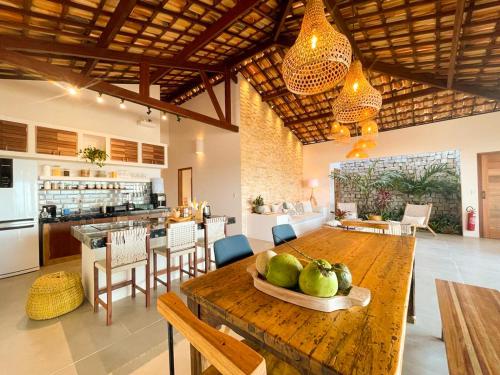 una cocina y comedor con una mesa con peras. en Casa ADOBE Preá - FRENTE MAR! en Prea