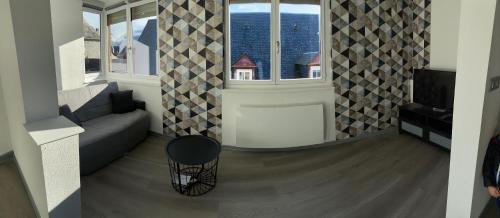 ein Wohnzimmer mit Couch und großem Fenster in der Unterkunft Résidence avec un T3 un T2 et un STUDIO en Centre Ville d Argeles-Gazost in Argelès-Gazost