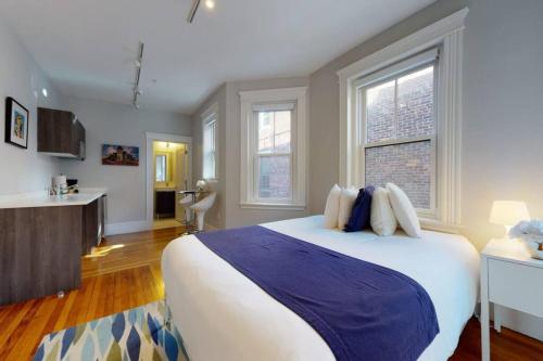 a bedroom with a large bed and two windows at A Stylish Stay w/ a Queen Bed, Heated Floors.. #22 in Brookline