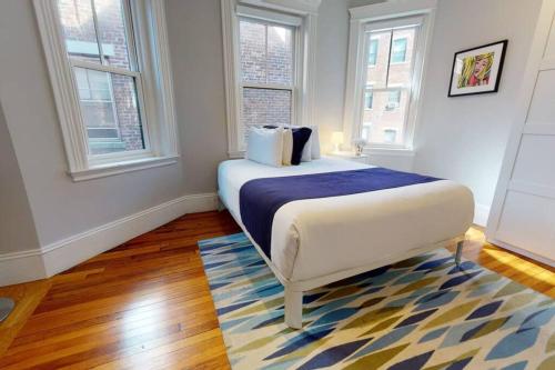a bedroom with a bed in a room with windows at A Stylish Stay w/ a Queen Bed, Heated Floors.. #22 in Brookline