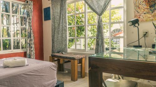 a bedroom with a bed and a window and a desk at Casa del Pintor Chetumal in Chetumal