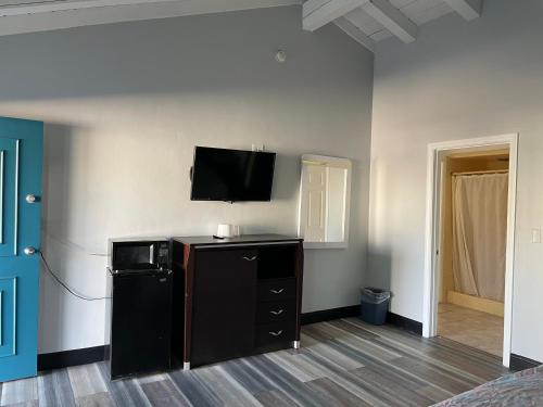 a room with a flat screen tv on a wall at La Casa Motel, Garden Grove - Anaheim in Garden Grove