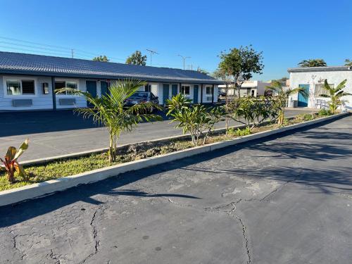 an empty street in front of a building with palm trees at La Casa Motel, Garden Grove - Anaheim in Garden Grove