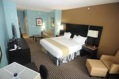 サマセットにあるHoliday Inn Express Somerset, an IHG Hotelの大きなベッドとソファが備わるホテルルームです。